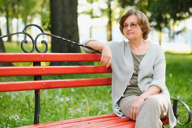 Portrait d'une femme âgée heureuse dans un parc d'été