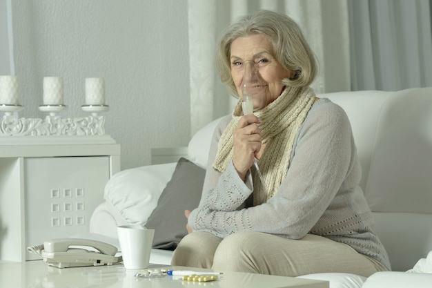 Portrait de femme âgée avec inhalation de grippe