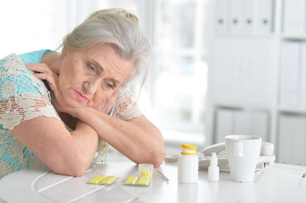 Portrait d'une femme âgée malade avec des médicaments