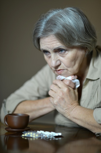 Portrait de femme âgée malade prenant des pilules