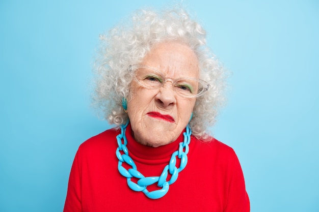 Portrait d'une femme âgée mécontente avec une expression de visage agacée et malheureuse