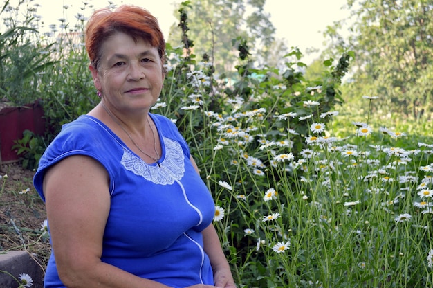 Portrait d'une femme âgée posant à côté de fleurs