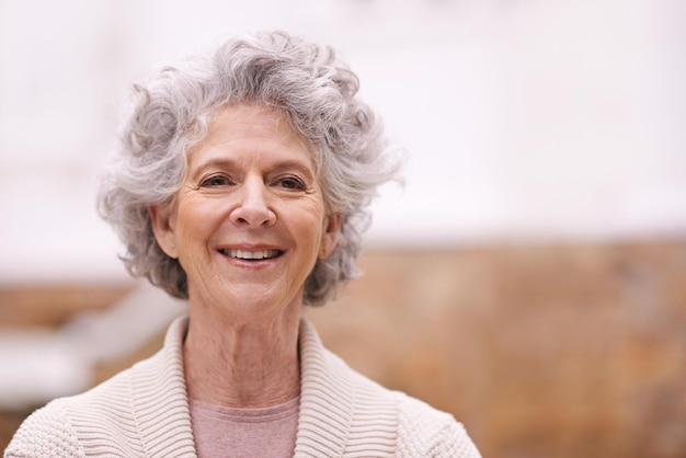 Portrait d'une femme âgée souriante debout à l'extérieur