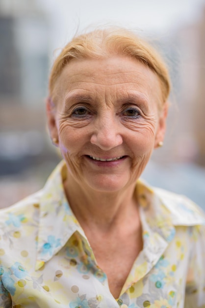 Portrait d'une femme âgée souriante à l'extérieur