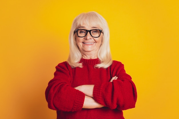 Portrait d'une femme âgée souriante isolée sur fond jaune