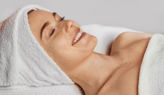 Portrait d'une femme allongée sur une chaise longue dans un salon de spa attendant le début de la thérapie