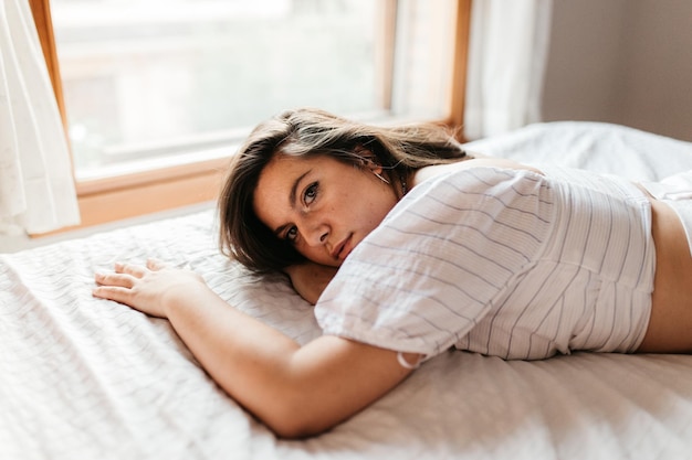 Portrait d'une femme allongée sur le lit à la maison