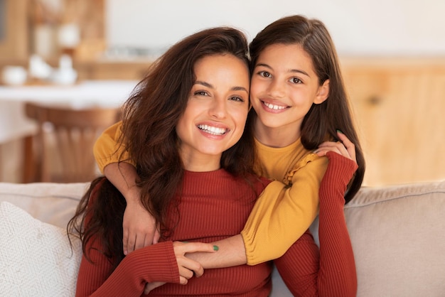 Portrait d'une femme arabe heureuse et de sa fille qui s'embrassent à la maison