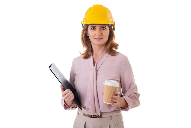 Photo portrait d'une femme architecte en casque tenant un dossier de presse-papiers et une tasse de café à emporter isolée