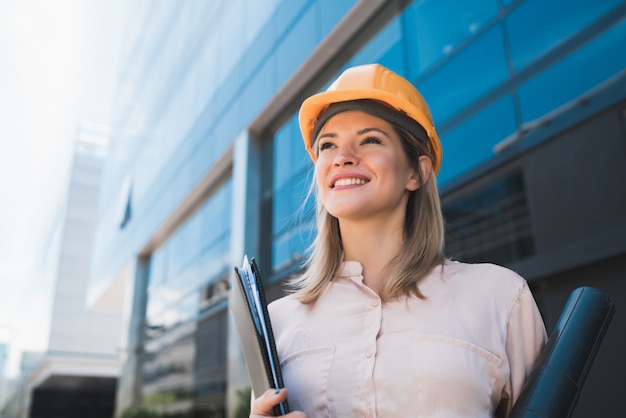 Portrait de femme architecte professionnelle portant un casque jaune et debout à l'extérieur. Concept d'ingénieur et d'architecte.