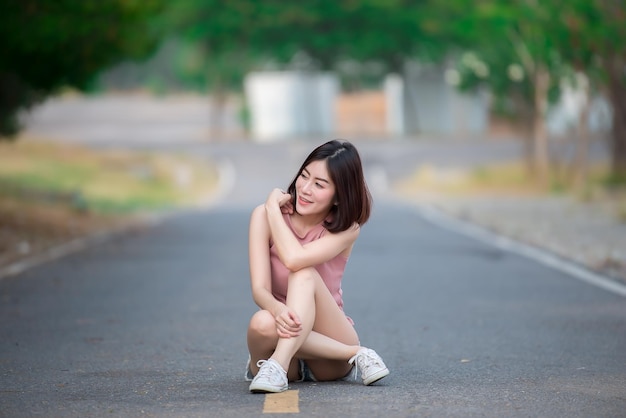 Portrait d'une femme asiatique assise sur la route