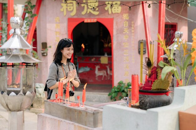 Portrait de femme asiatique disant des prières et les yeux se ferment devant le sanctuaire chinois local à Bangkok en Thaïlande