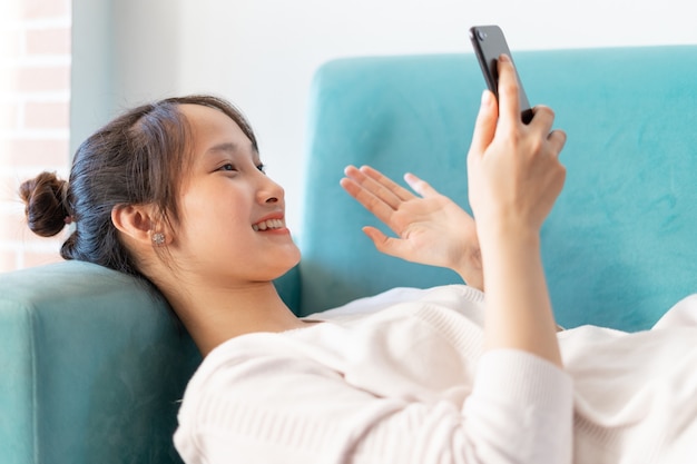 Portrait de femme asiatique à la maison, sur canapé