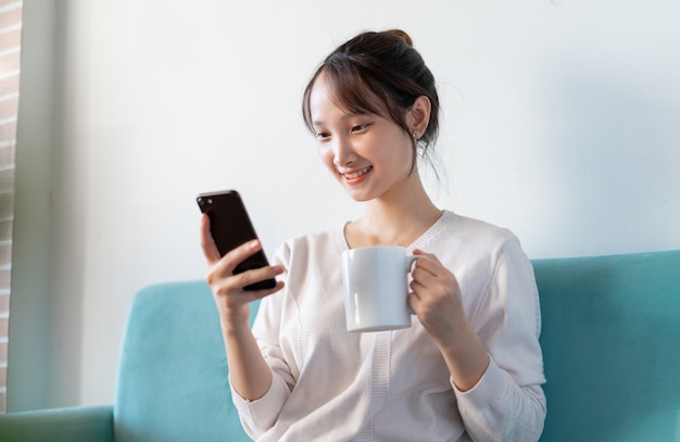 Portrait de femme asiatique à la maison, sur canapé