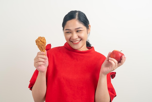 Portrait femme asiatique avec poulet frit et pomme sur place pour le choix
