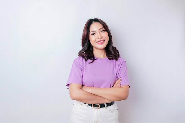 Portrait d'une femme asiatique souriante confiante debout avec les bras croisés et regardant la caméra isolée sur fond blanc