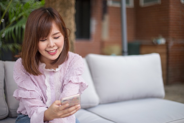 Photo portrait, femme asiatique, utilisation, smartphone, café, jardin