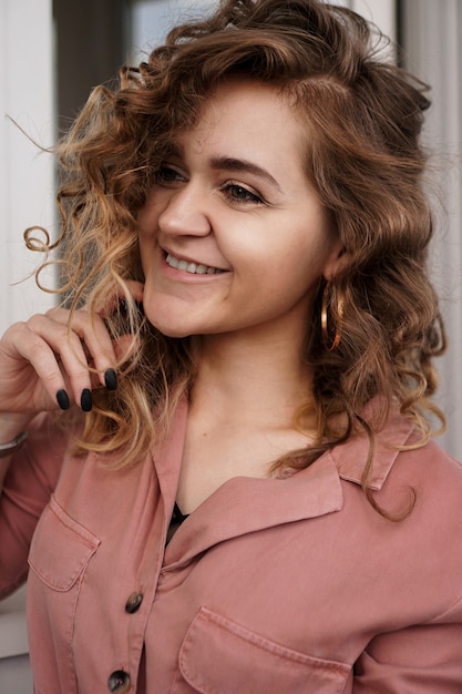 Portrait d'une femme assez heureuse aux cheveux bouclés