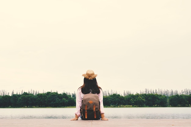 Portrait d'une femme assise au bord d'un lac contre un ciel clair