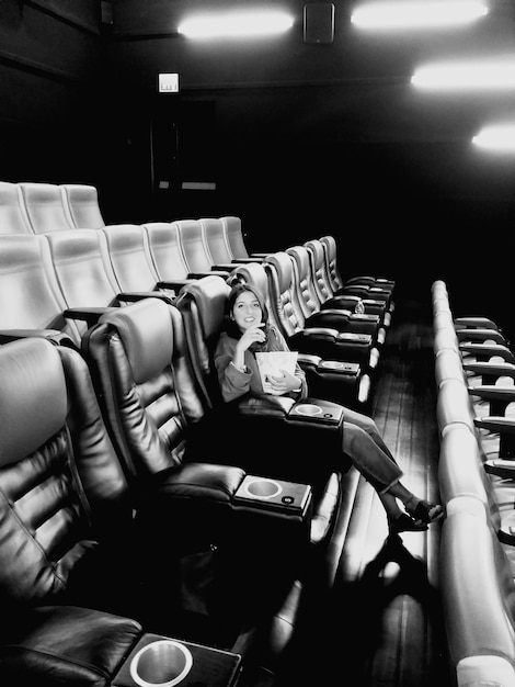 Photo portrait d'une femme assise sur une chaise dans un cinéma