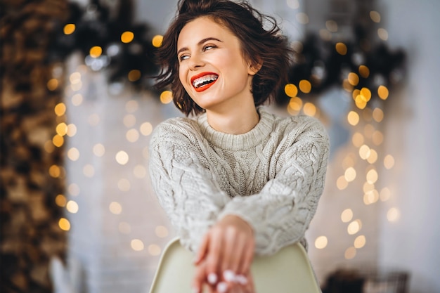 Portrait femme assise sur la chaise près de l'arbre de Noël