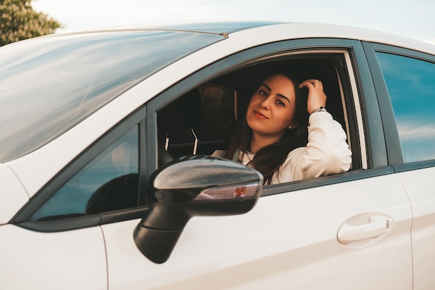 Photo portrait d'une femme assise sur la fenêtre d'une voiture