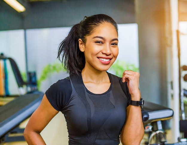 Portrait de femme athlétique afro-américaine en vêtements de sport noirs faisant de l'exercice dans un gymnase professionnel