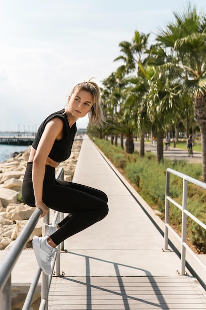 Portrait de femme athlétique relaxante après l'entraînement de rue d'été