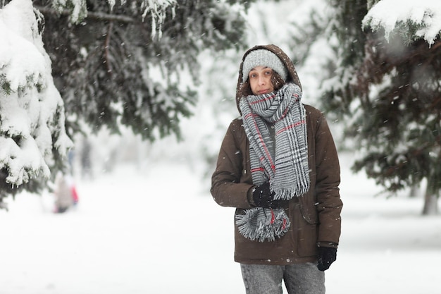 Portrait d'une femme attirante dans des vêtements chauds en hiver par temps de neige à l'extérieur