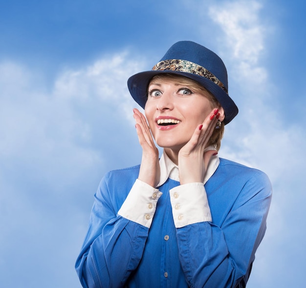 Portrait d'une femme au chapeau bleu avec les mains