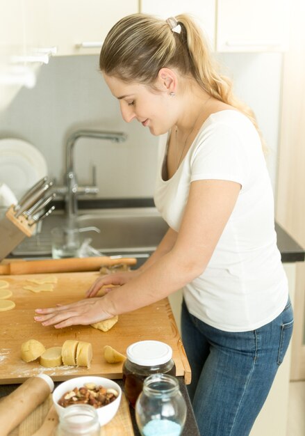 Portrait de femme au foyer faisant de la pâte dans la cuisine