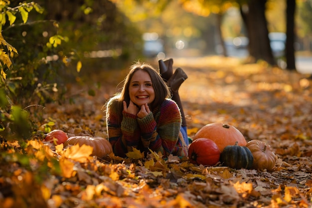 Portrait d'une femme au sourire heureux avec des citrouilles à la main