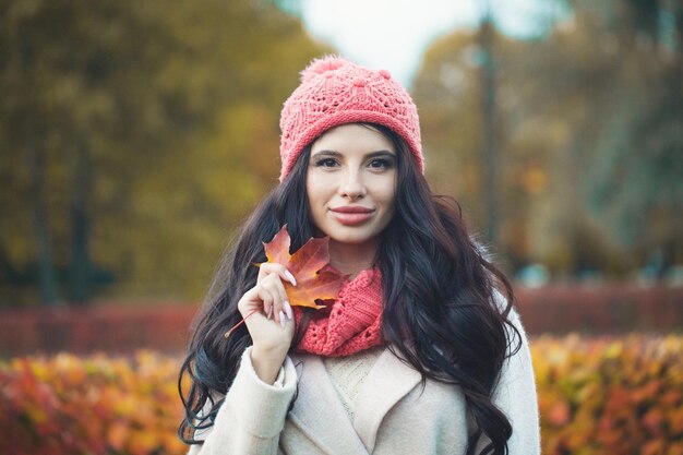 Portrait de femme automne fille mannequin avec feuille d'érable d'automne à l'extérieur dans le parc d'automne