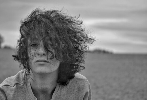 Photo portrait d'une femme aux cheveux en désordre contre le ciel