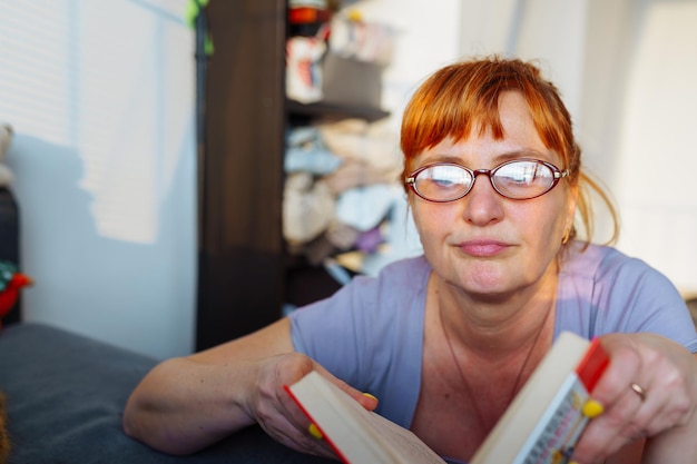 Portrait d'une femme aux cheveux roux lisant un roman