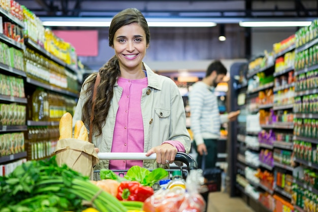 Portrait de femme aux légumes dans le caddie