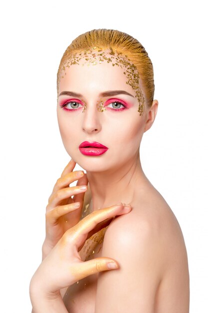 Portrait de femme de beauté. Fille de beau modèle avec une peau propre et fraîche et un maquillage professionnel doré brillant. Femme blonde sur mur blanc avec maquillage rose et or du soir