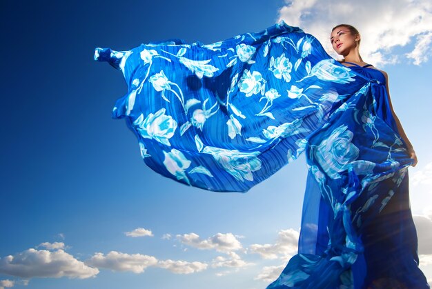 Portrait d'une femme de beauté en robe bleue sur le désert