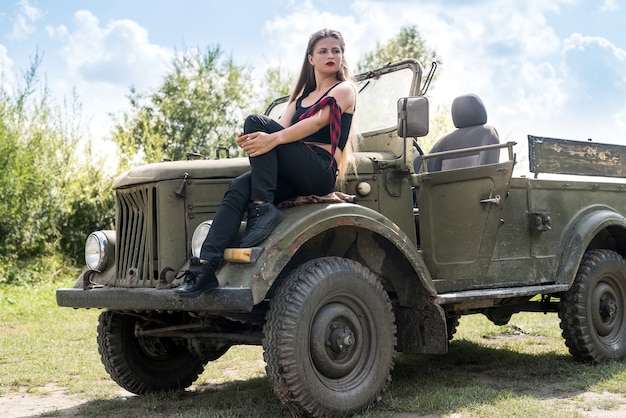 Portrait de femme belle cheveux longs assis sur le capot de la voiture