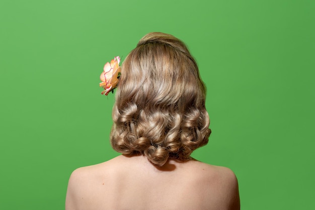 Portrait d'une femme blonde aux cheveux bouclés dans un style rétro isolé sur fond vert