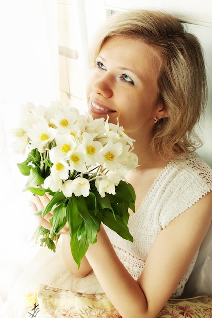 Portrait de femme blonde avec un bouquet d'hellébore