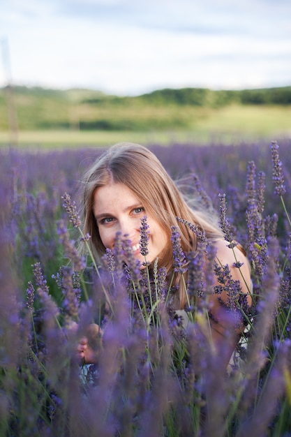 Portrait de femme blonde parfaite souriante en plein air