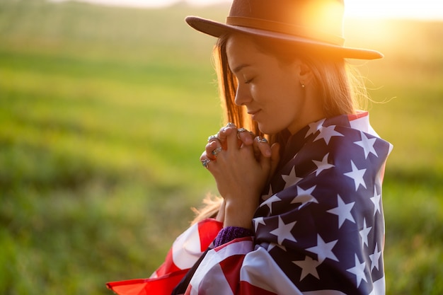 Portrait de femme bohème chic avec chapeau à drapeau américain portant des bagues en argent avec pierre turquoise au coucher du soleil. Bijoux indie girl avec style hippie et mode boho. Voyage en Amérique