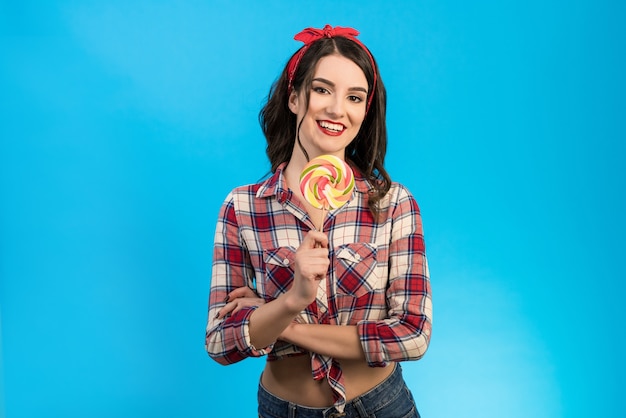 Le portrait de la femme avec un bonbon sur fond bleu