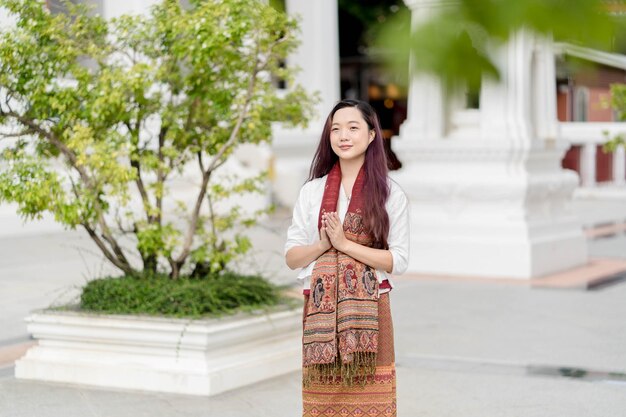 Portrait femme bouddhiste asiatique portant des vêtements traditionnels de Thaïlande priant au Wat Ratchanatdaram bangkok