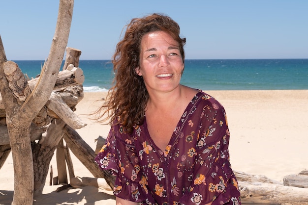 Portrait de femme brune regardant de côté sur la plage de sable de vacances d'été