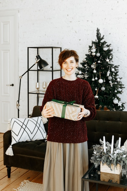 portrait femme avec cadeau de Noël à la maison