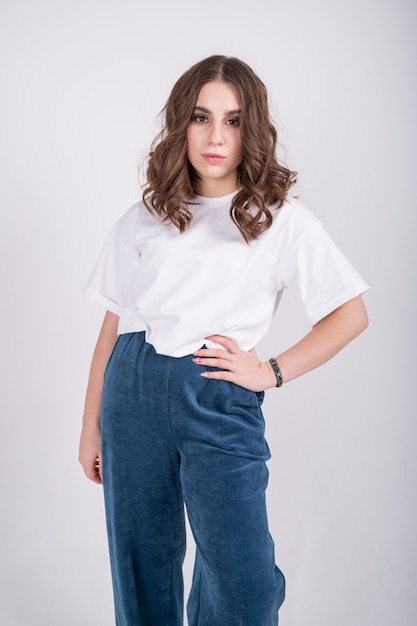 Portrait de femme caucasienne agréable avec des cheveux bruns portant un tshirt occasionnel blanc et bleu