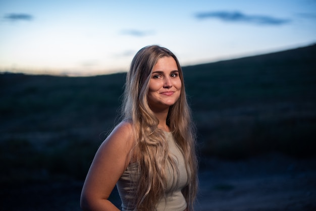 Portrait d'une femme caucasienne blonde souriante tout en s'assombrissant