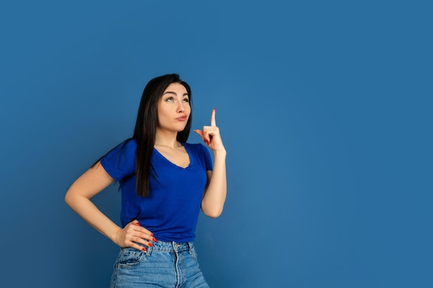 Portrait de femme caucasienne isolé sur le mur bleu du studio